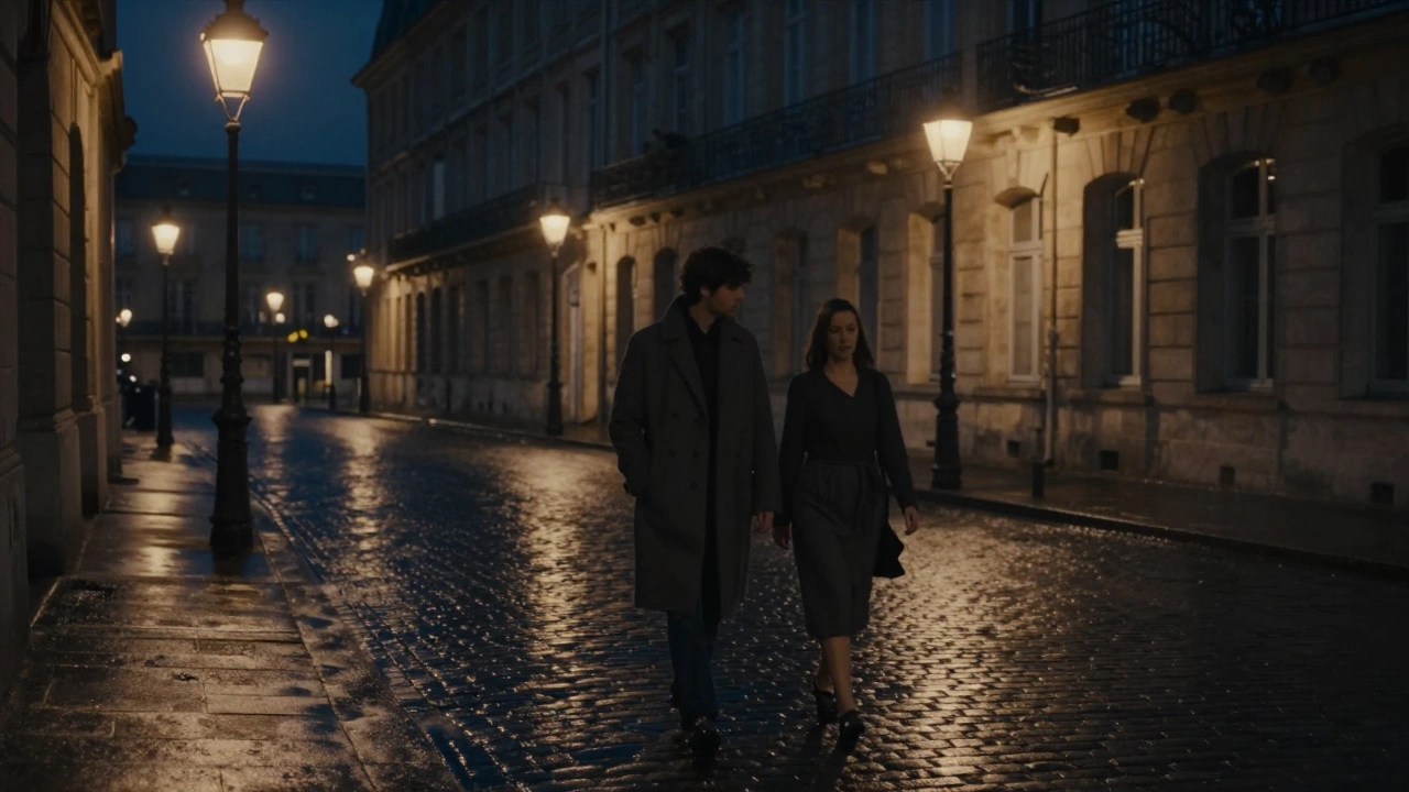Two figures walk silently under streetlamps in Bordeaux, their hands nearly touching on a wet cobblestone street.